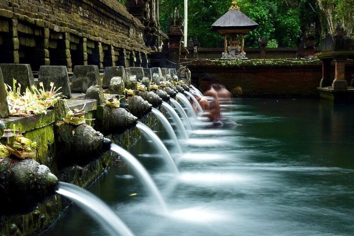 a water fountain in a park with people in it