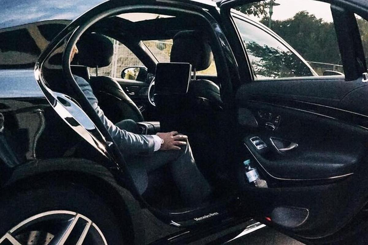 dos personas sentadas en el asiento del conductor de un coche
