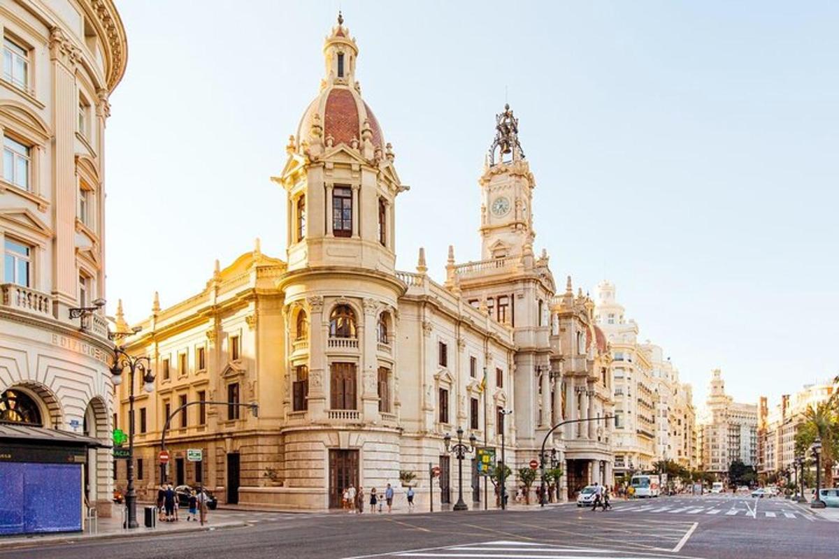 Un gran edificio con una torre de reloj en una calle.