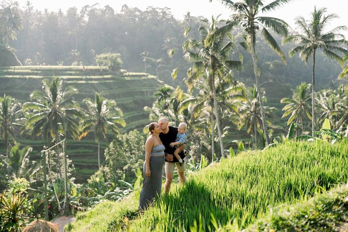 a man and a woman holding a child on a hill