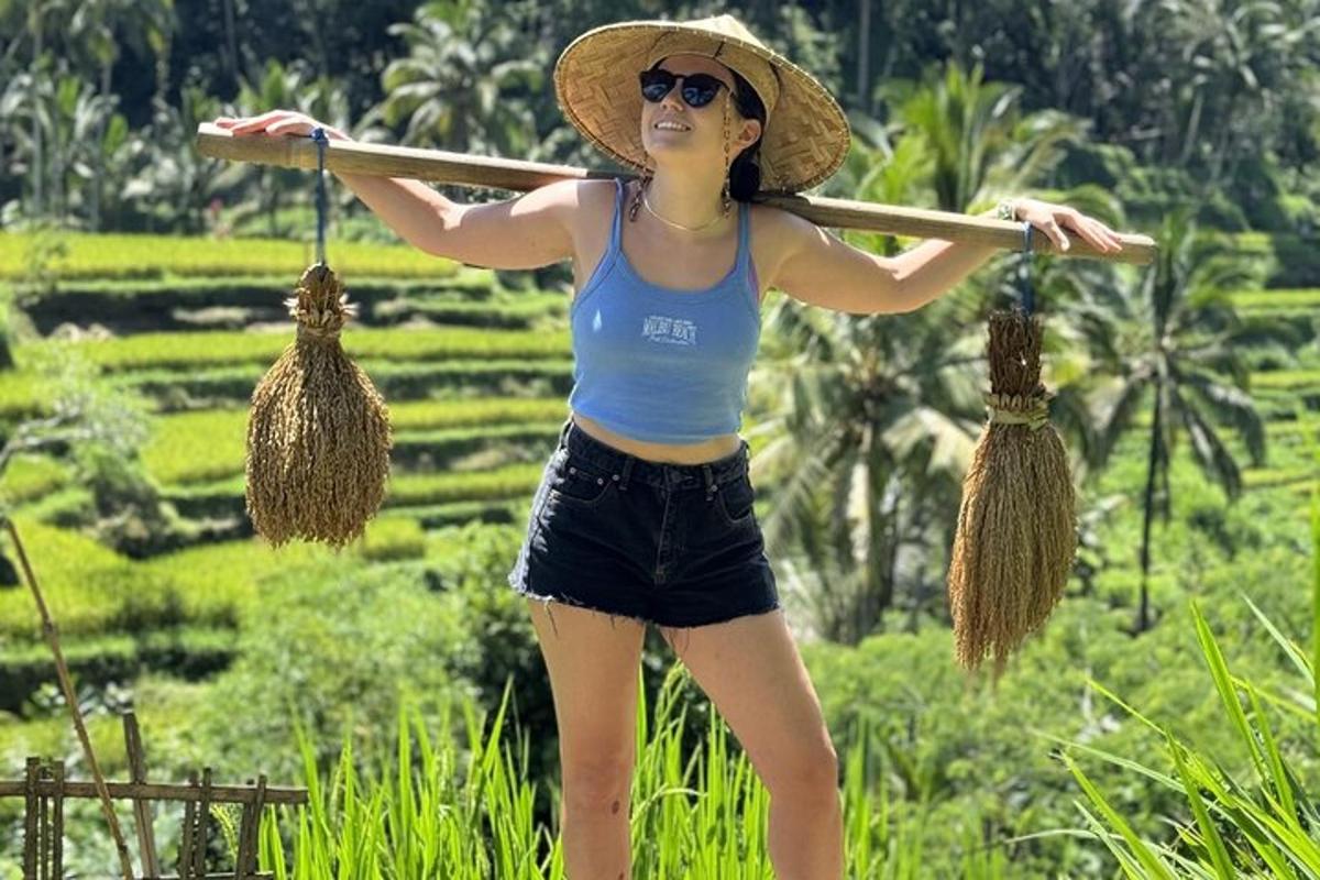 a woman in a straw hat holding a wooden stick