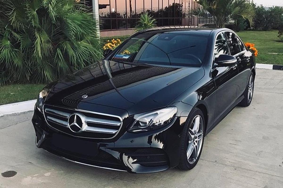 un'auto Mercedes Benz nera parcheggiata in un vialetto