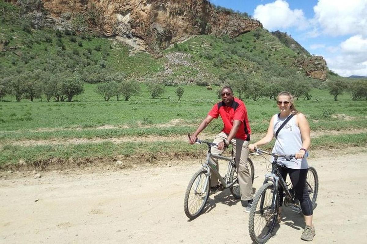 um homem e uma mulher andando de bicicleta em uma estrada de terra