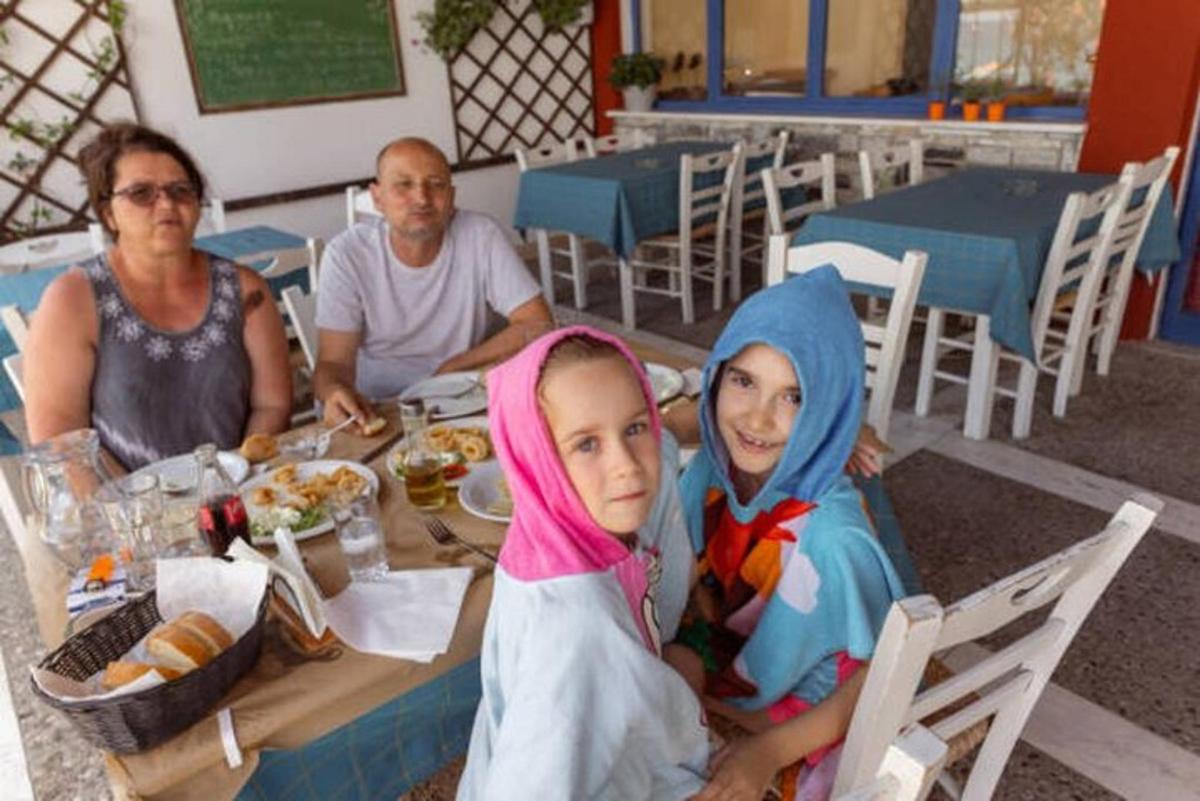 Un grupo de personas sentadas en una mesa comiendo comida