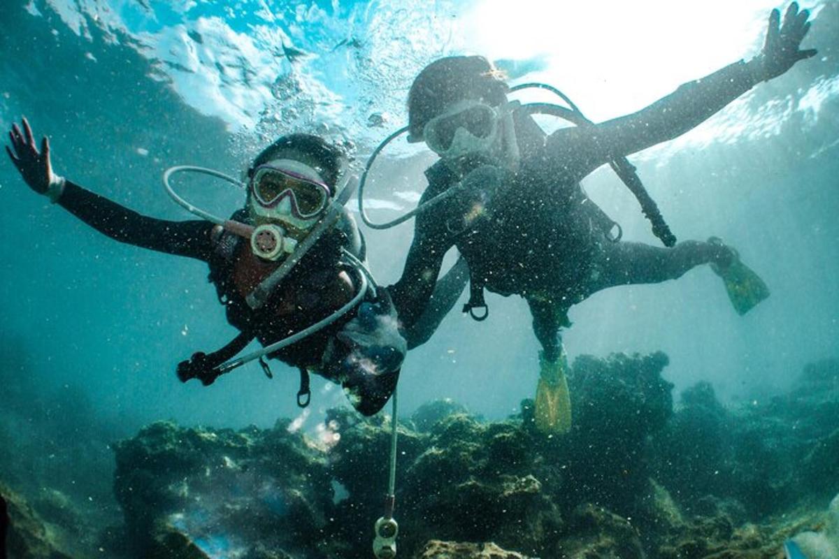 Două persoane înoată în apa de lângă ocean