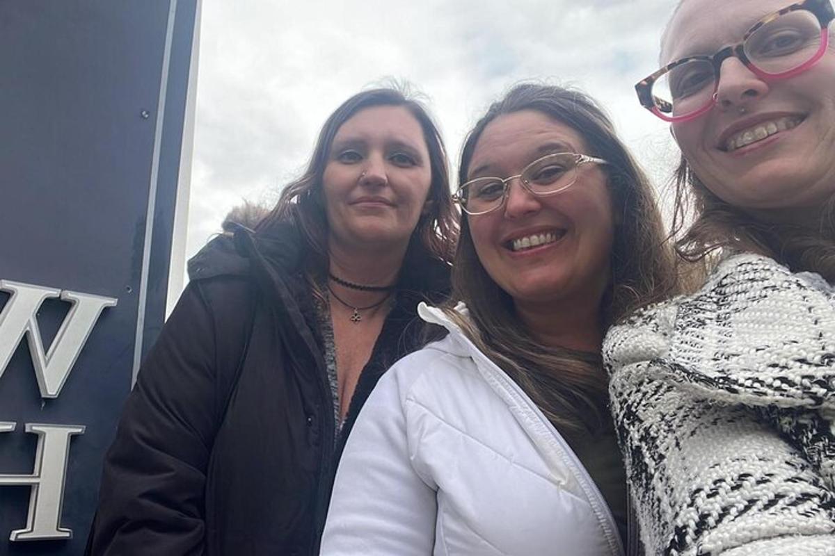 tres dones estan dretes una al costat de l'altra