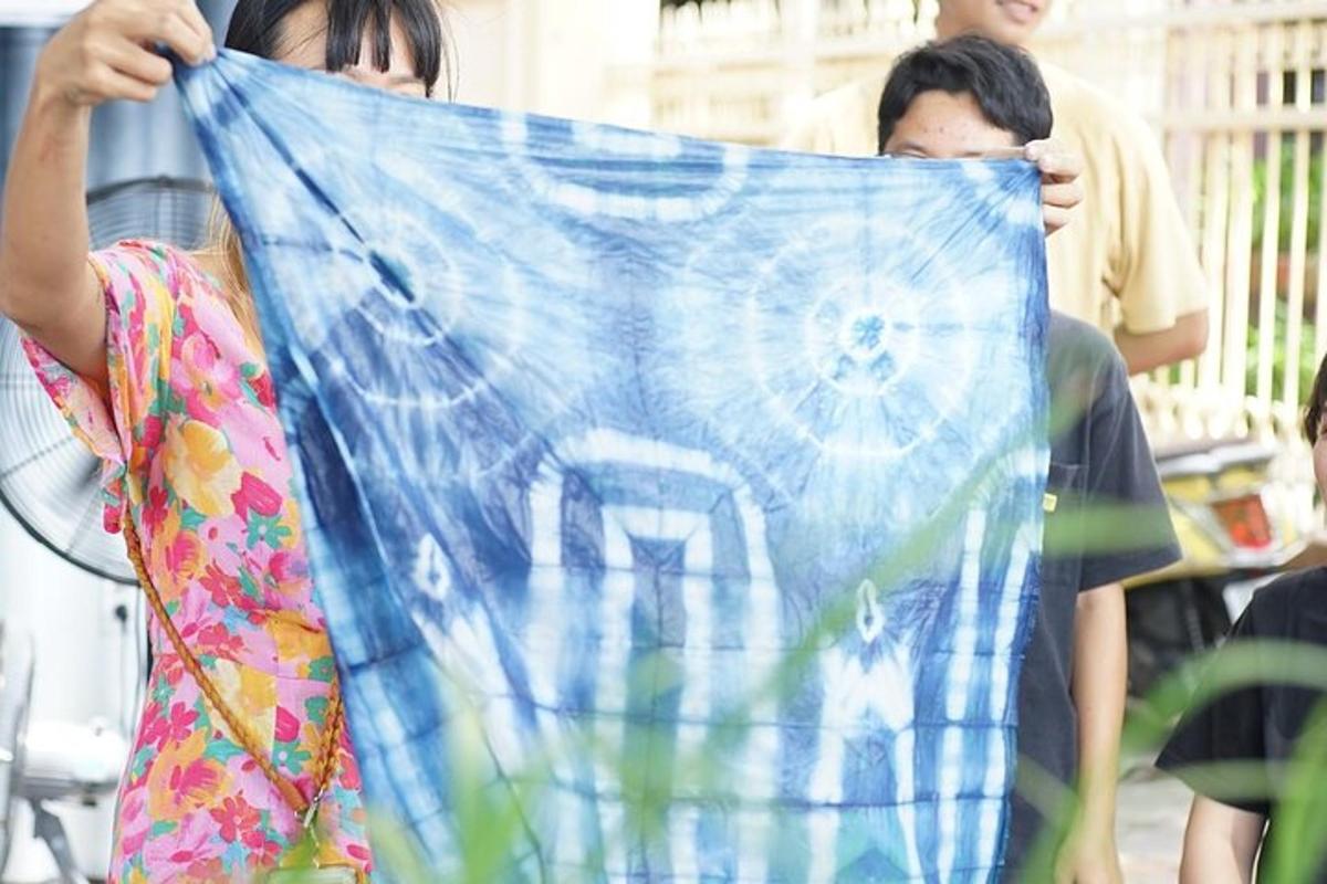 một người phụ nữ đang cầm một con diều có hình ngôi nhà trên đó