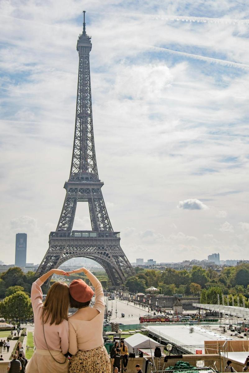 due donne in piedi davanti alla torre Eiffel