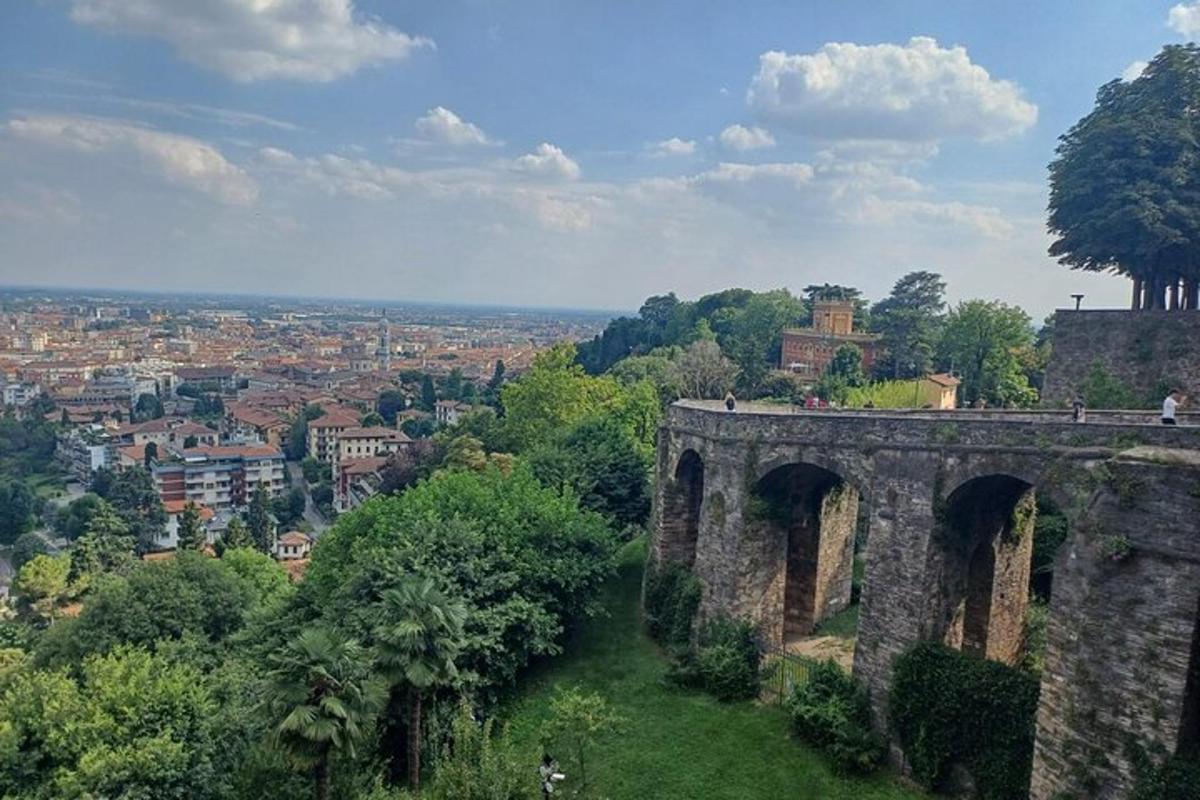 ein altes Gebäude auf einem Hügel mit einer Stadt im Hintergrund