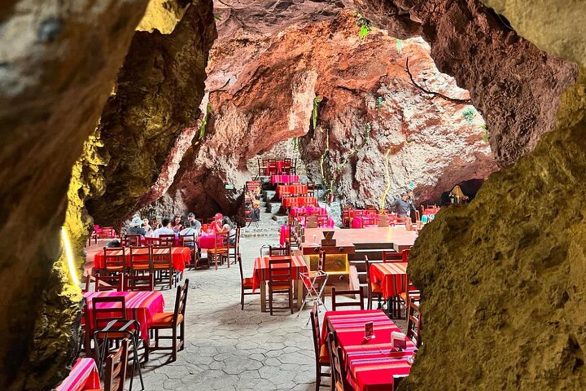 sebuah restoran dengan meja dan kursi merah di dalam gua
