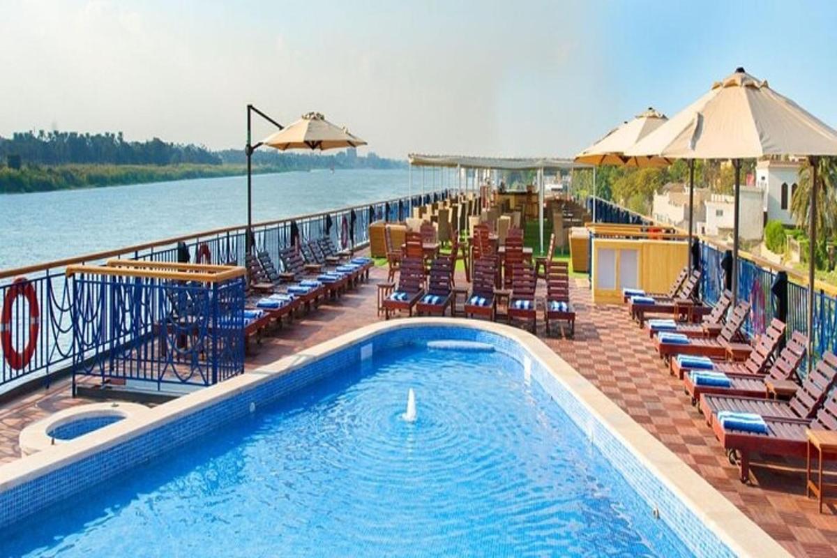 una piscina amb gandules i para-sols al costat de l'aigua