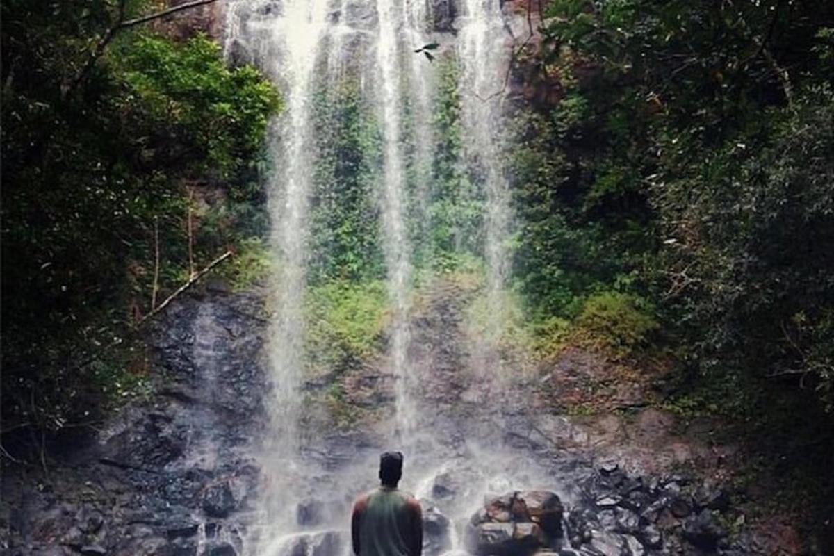 maður stendur fyrir framan foss