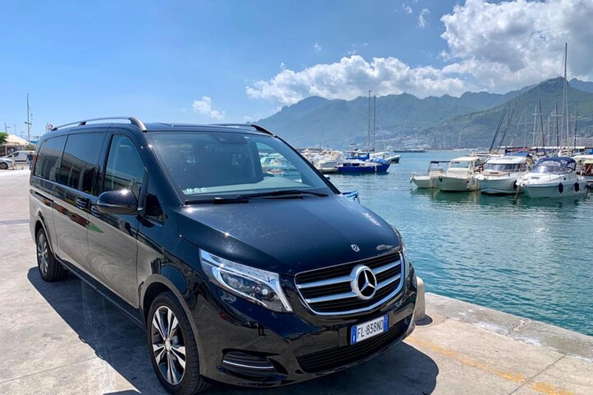 a blue mercedes benz suv parked next to a marina