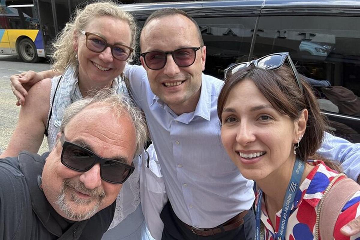 Čtyři lidé pózují pro fotografii před autem