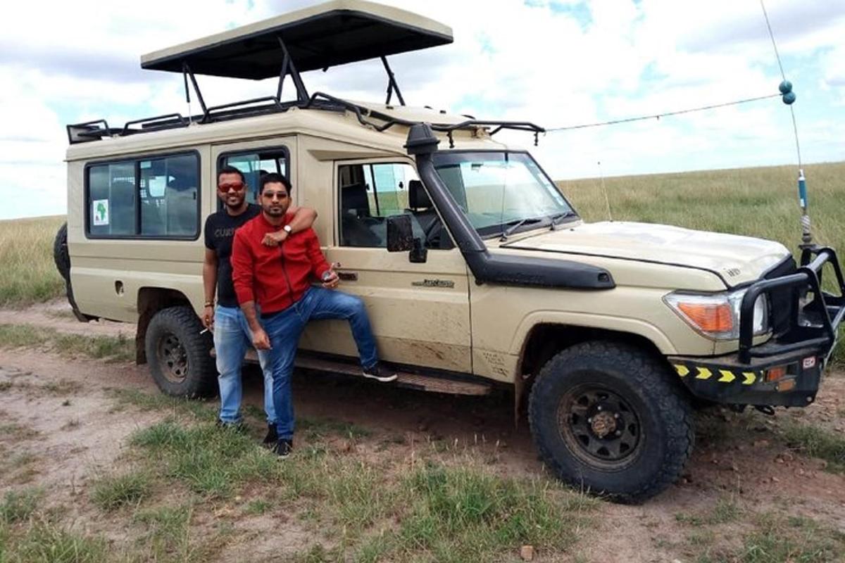 two men are standing in front of a jeep