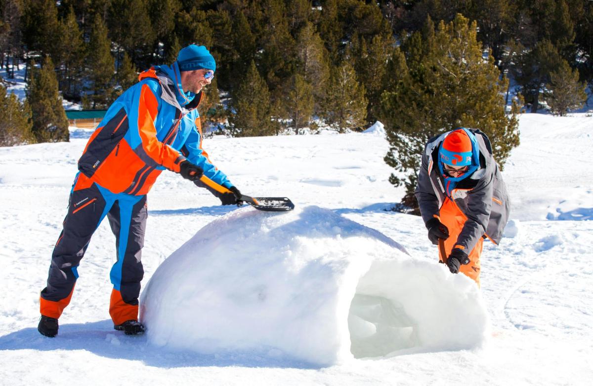 two men are playing with a snow man in the snow