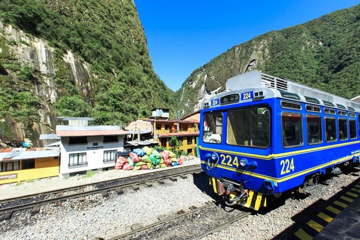 kereta api biru berjalan di rel dekat gunung
