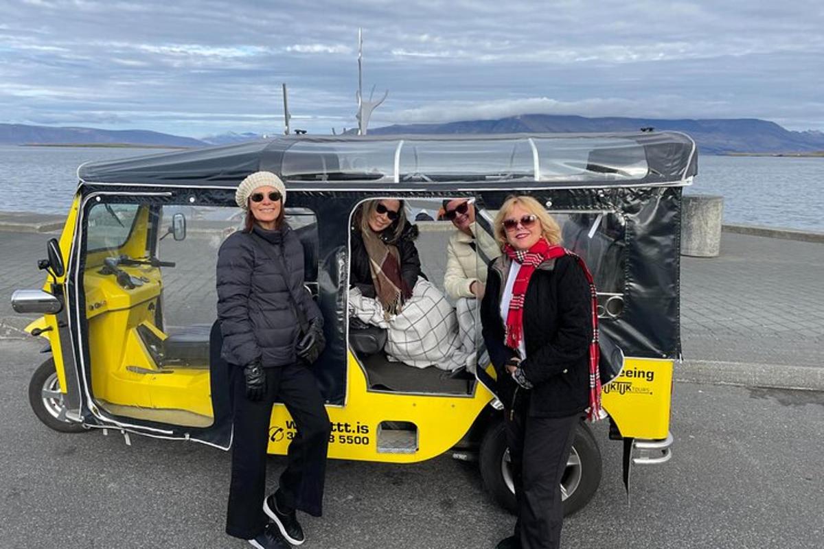 Három nő áll egy sárga golfkocsi hátuljában