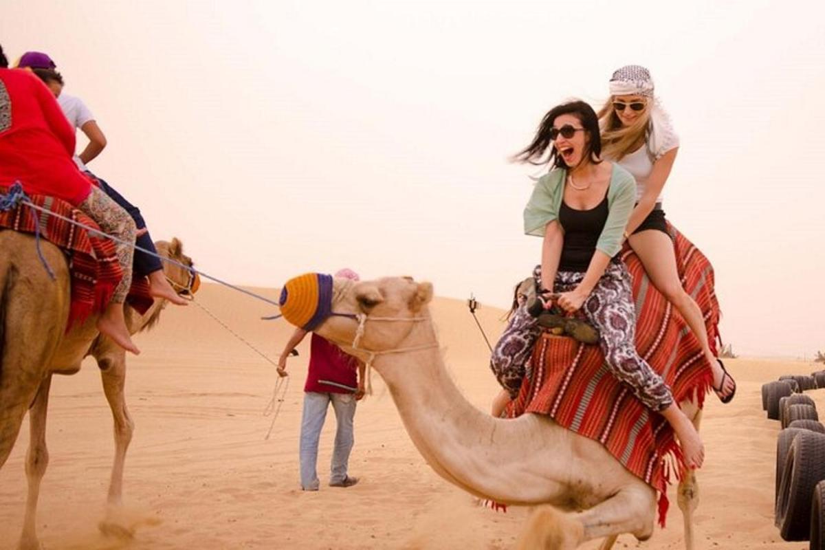 tres persones muntades en un camell al desert