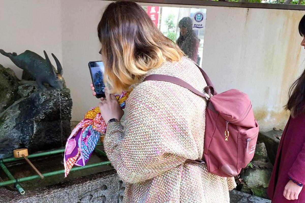 a woman taking a picture of an aquarium with her cell phone