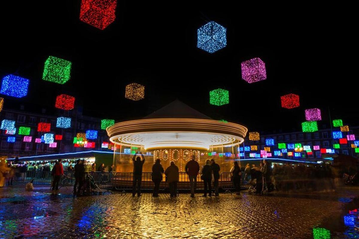 a group of people standing around a carousel with christmas lights