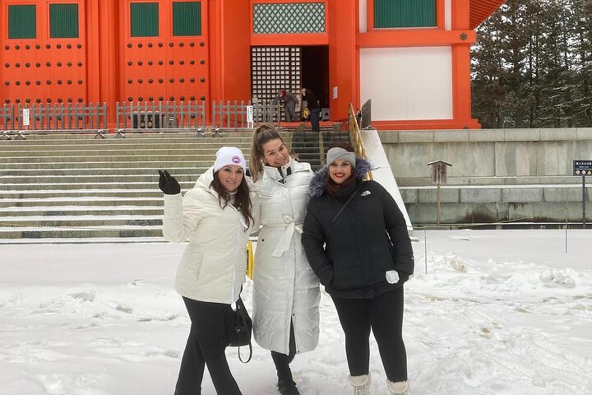 Tres mujeres paradas en la nieve frente a un edificio