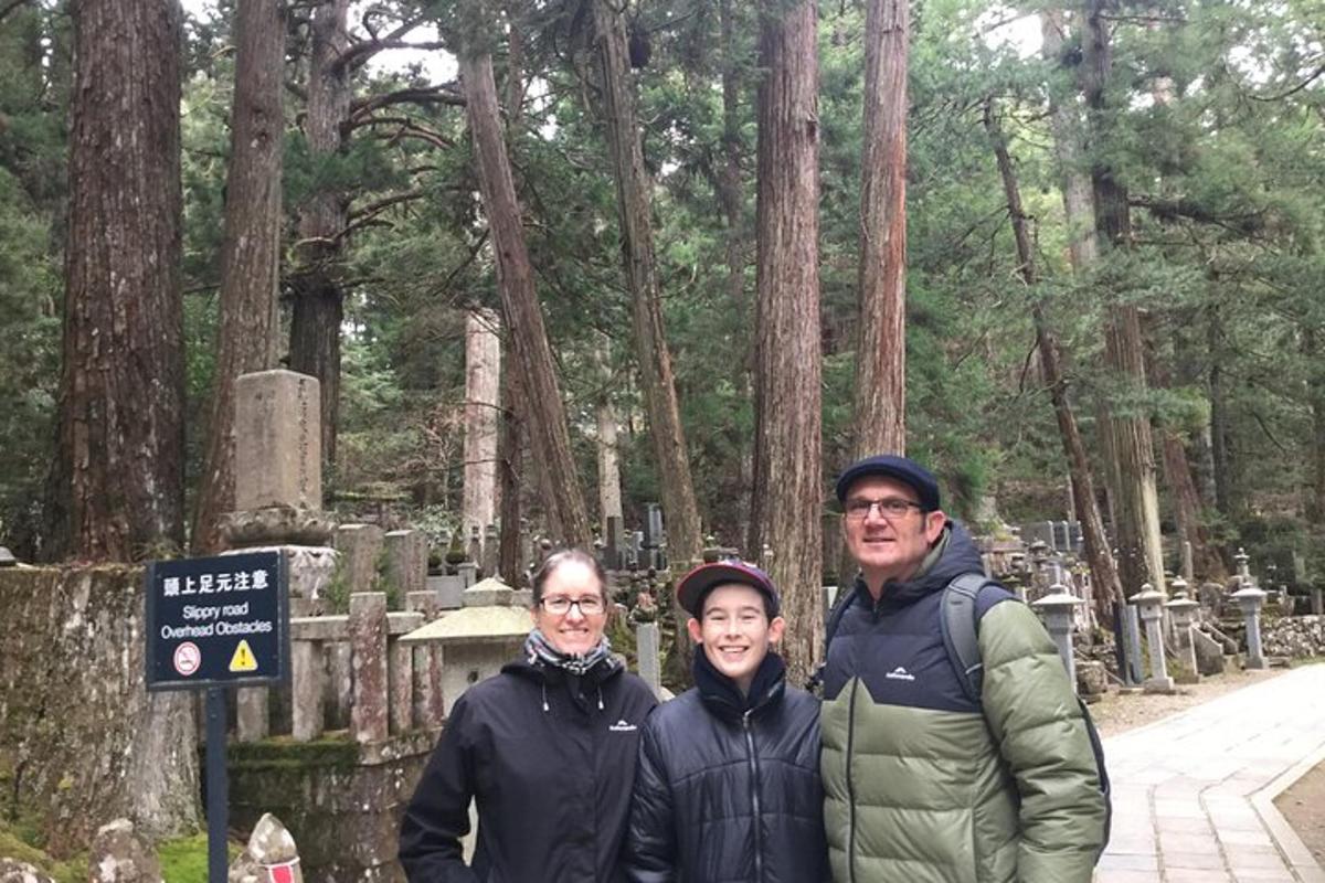 un gruppo di persone in piedi davanti a un cimitero