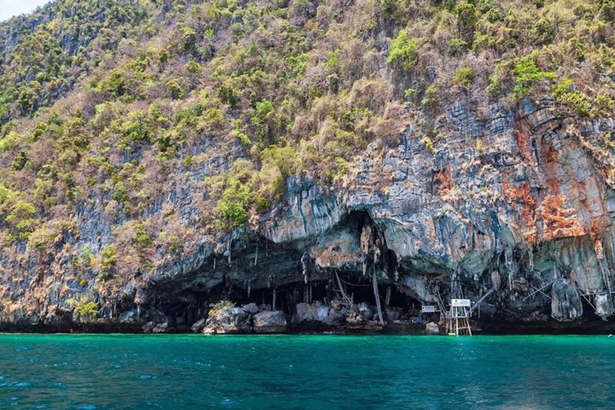 un barco en el agua junto a una montaña rocosa
