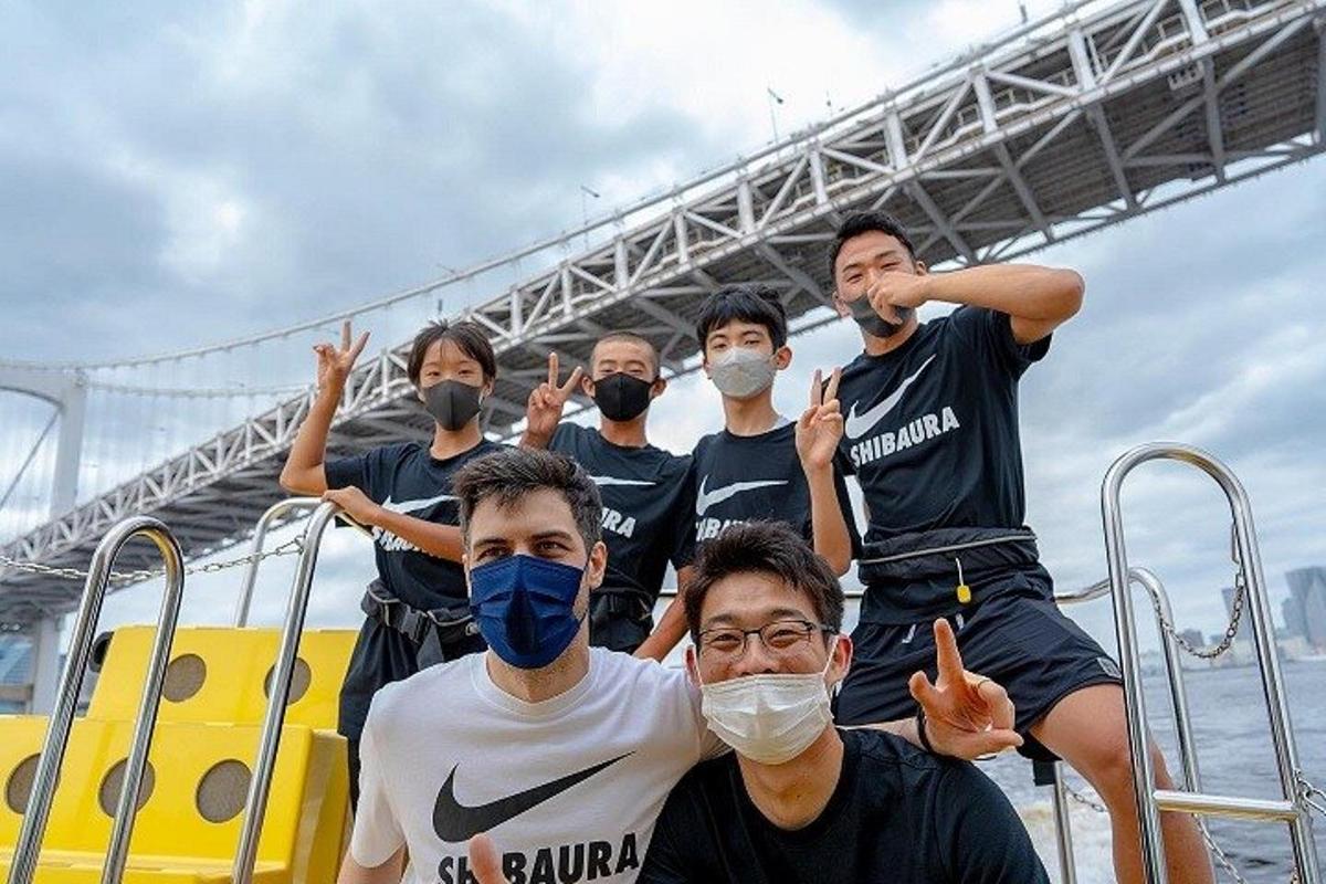 a group of people wearing masks posing in front of a bridge