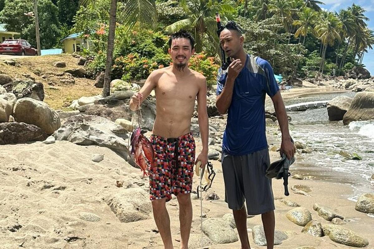 two men walking on the beach near the water