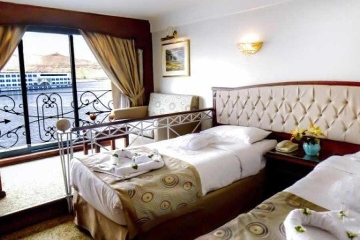 una camera d'albergo con due letti e un balcone