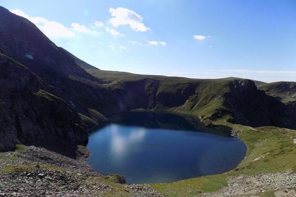 Un gran lago azul en medio de una montaña.