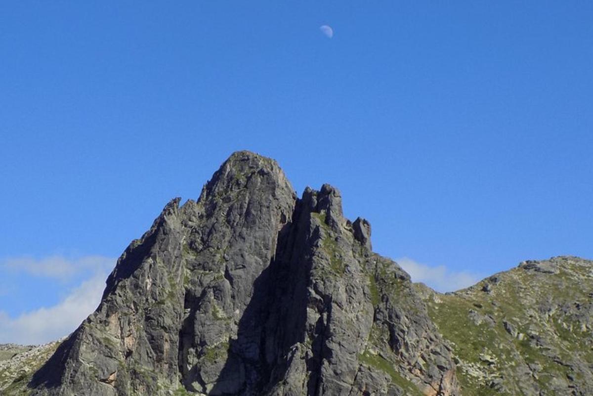 Un pico de montaña con un cielo azul al fondo