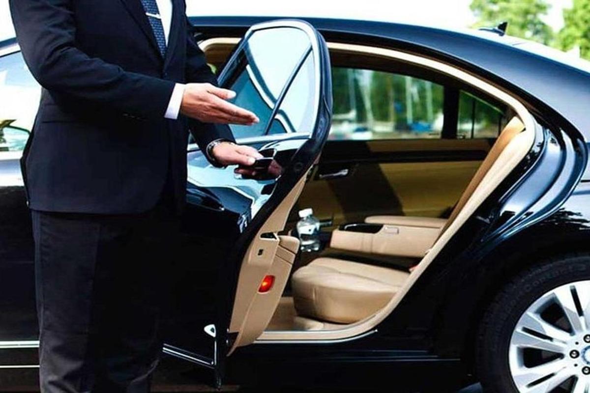 um homem de terno saindo de um carro