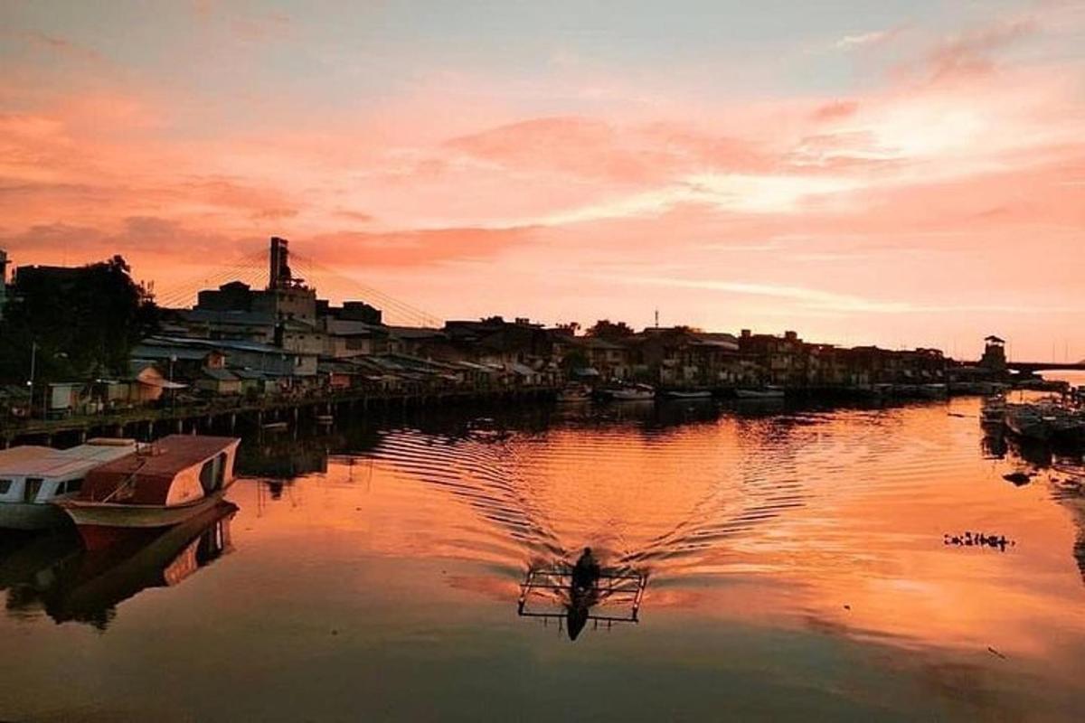 a boat is docked in a river at sunset
