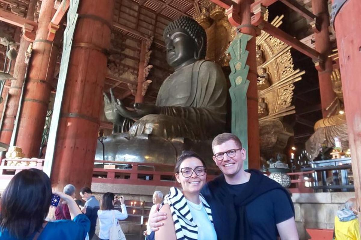 two people standing in front of a statue