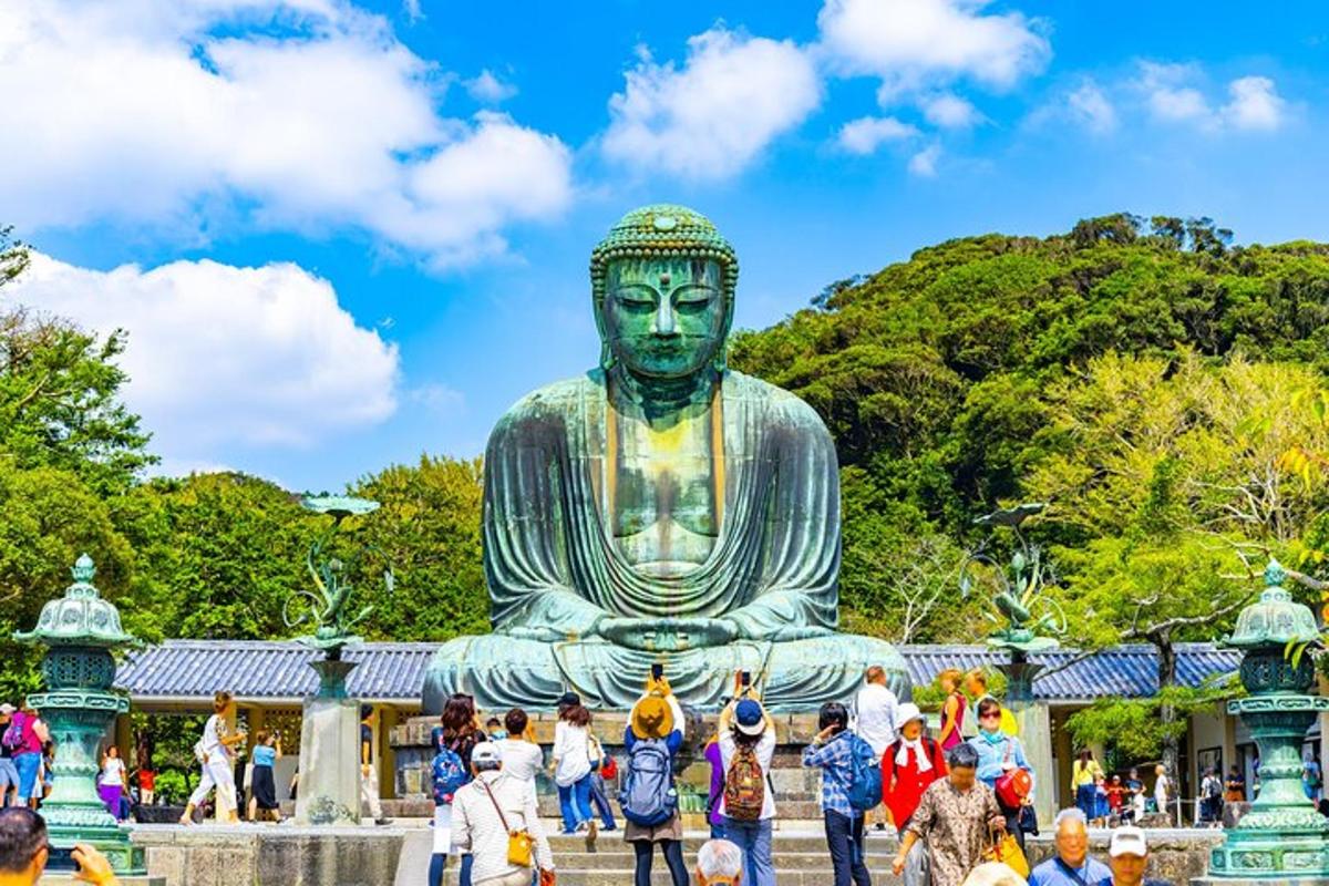 Una multitud de personas de pie alrededor de una gran estatua de Buda.