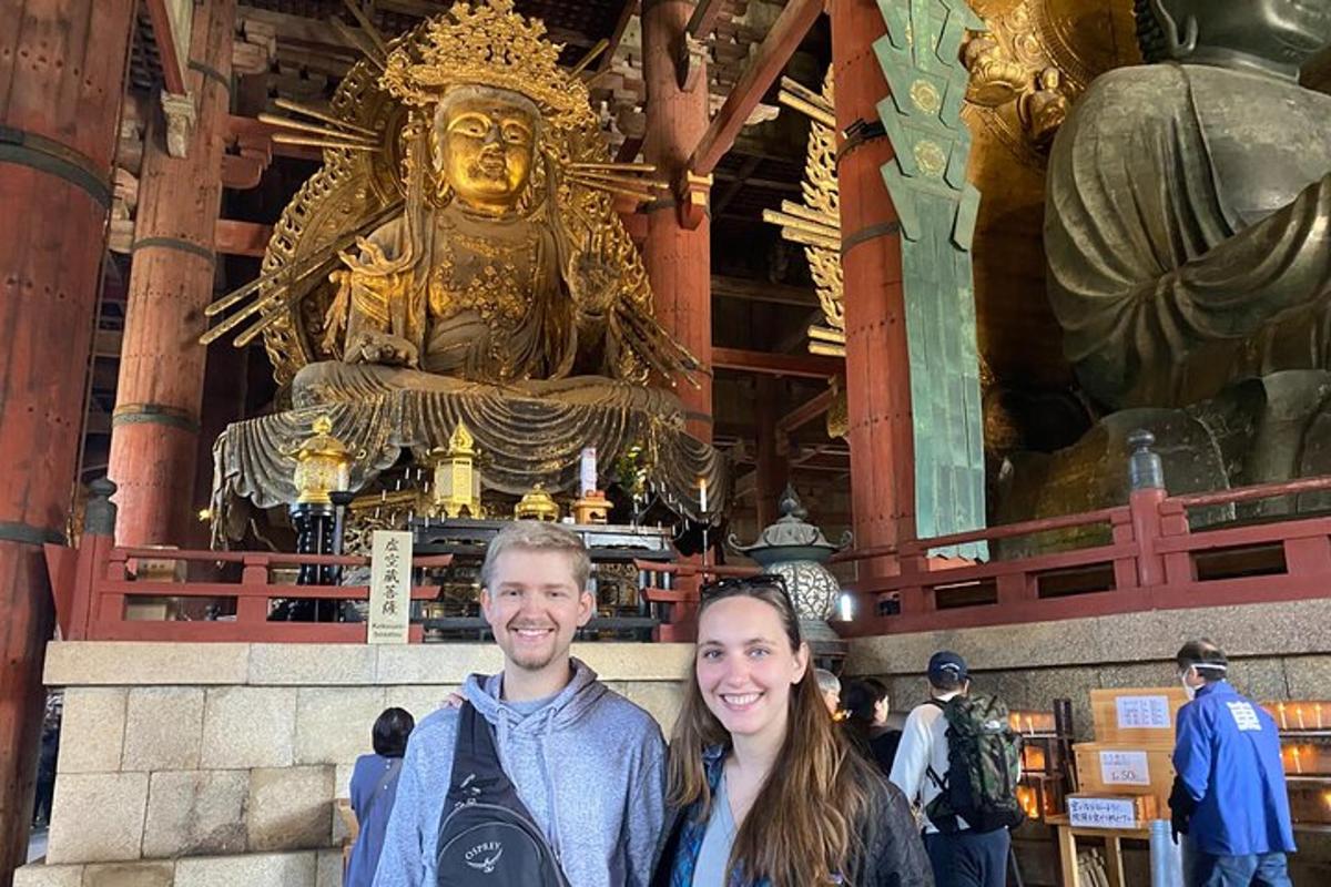 a man and a woman standing in front of a temple