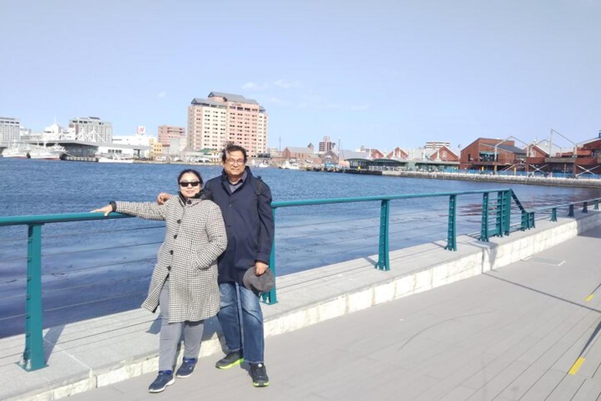 moški in ženska stojita na promenadi ob vodi