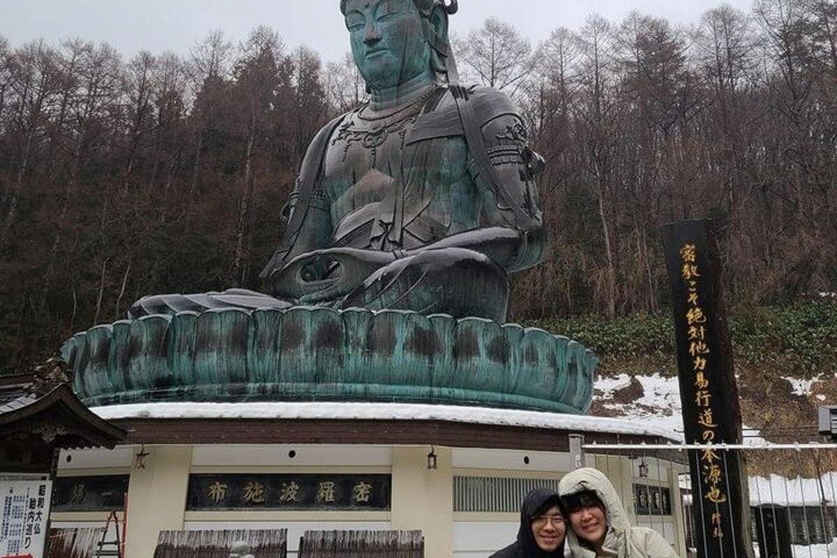 zwei Frauen stehen vor einer großen Statue