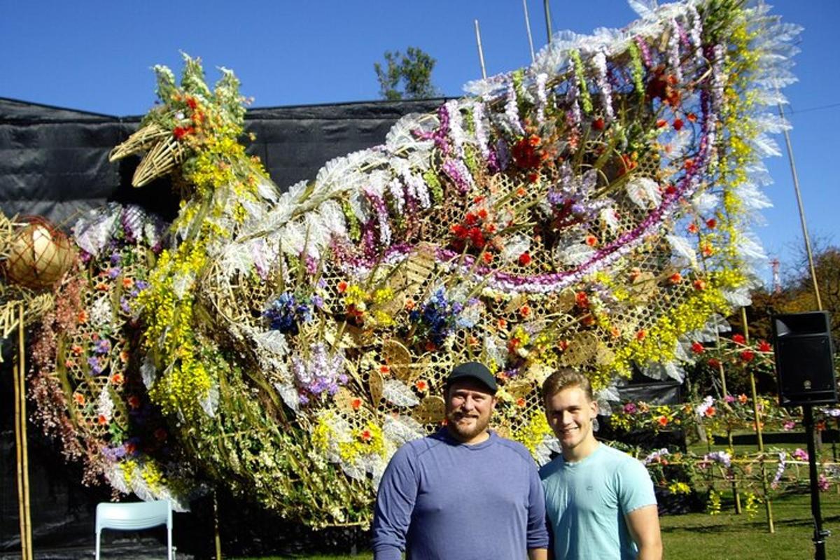 zwei Männer stehen vor einer Drachenskulptur