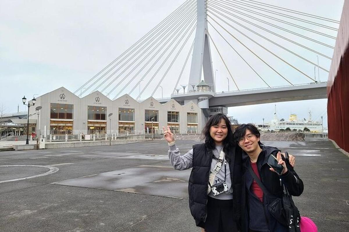 zwei Frauen posieren für ein Foto vor einer Brücke