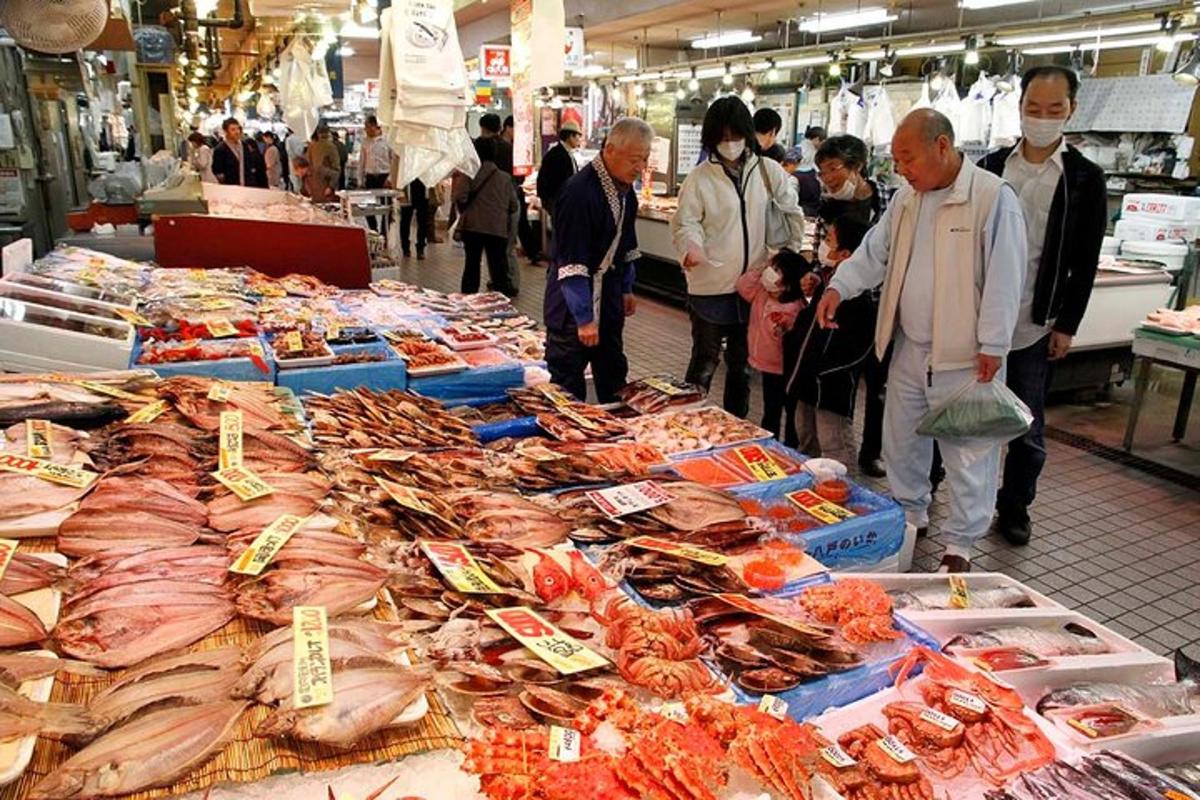 a group of people standing around a market with seafood