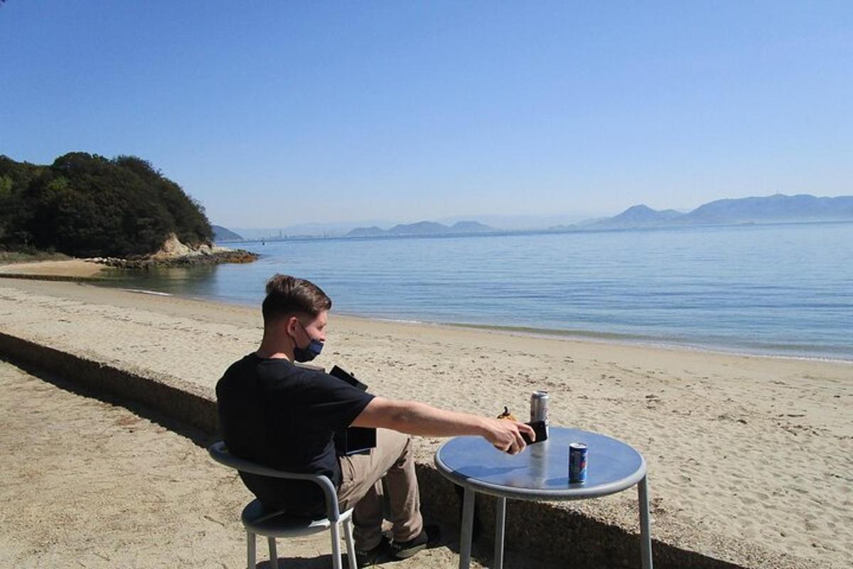 a man sitting at a table on the beach
