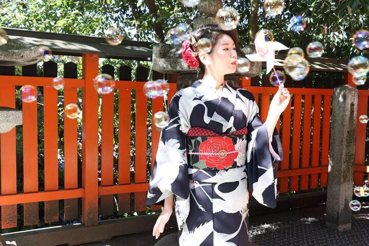 en kvinne i kimono som står foran et gjerde