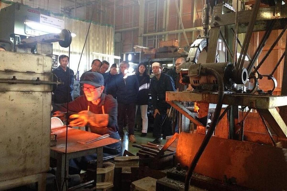 a group of people in a factory with a man working