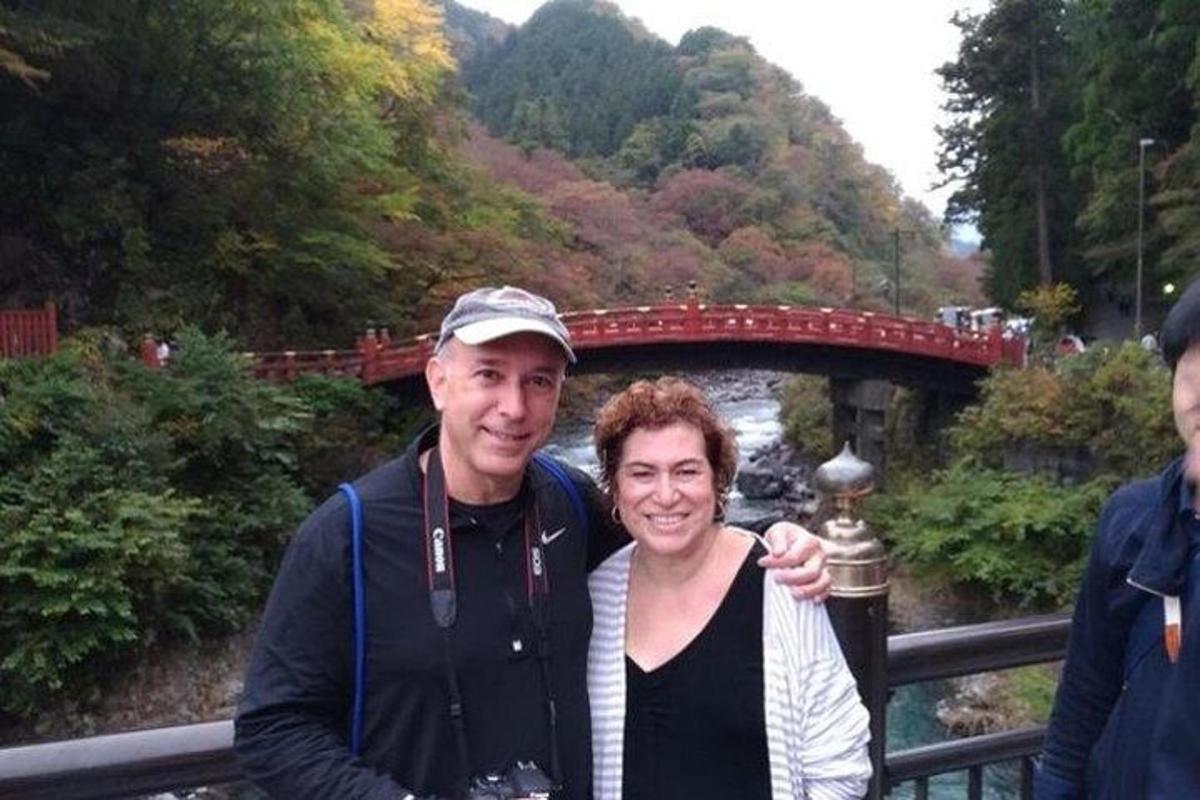 a man and a woman standing in front of a bridge