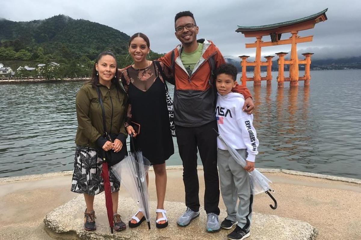 a family posing for a picture in front of a lake
