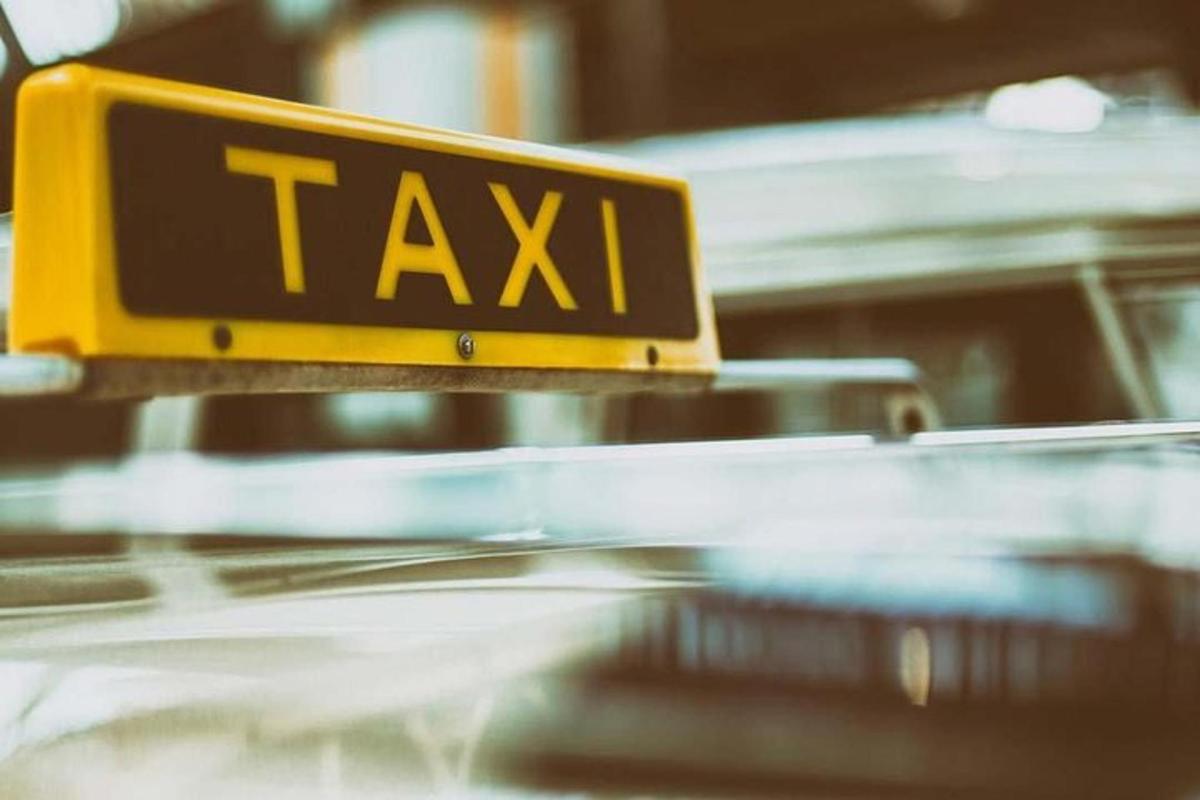 un semn de taxi deasupra unui taxi