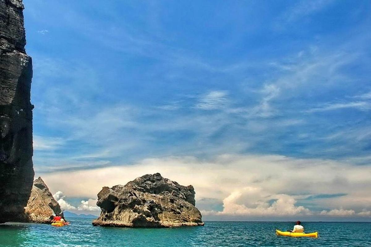 una persona in kayak in acqua vicino a una roccia